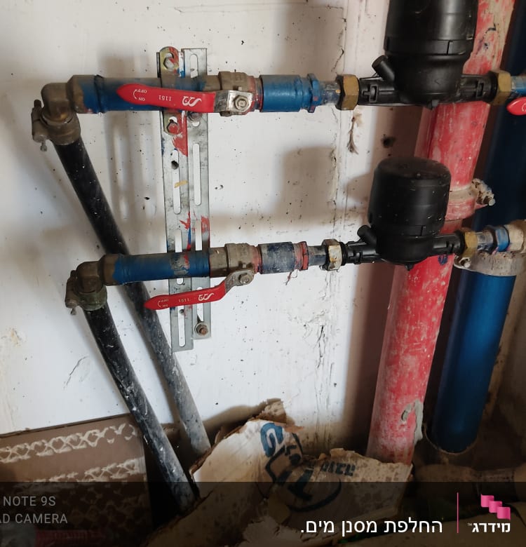 צינורות מים עם ברזים אדומים ומחברים שחורים